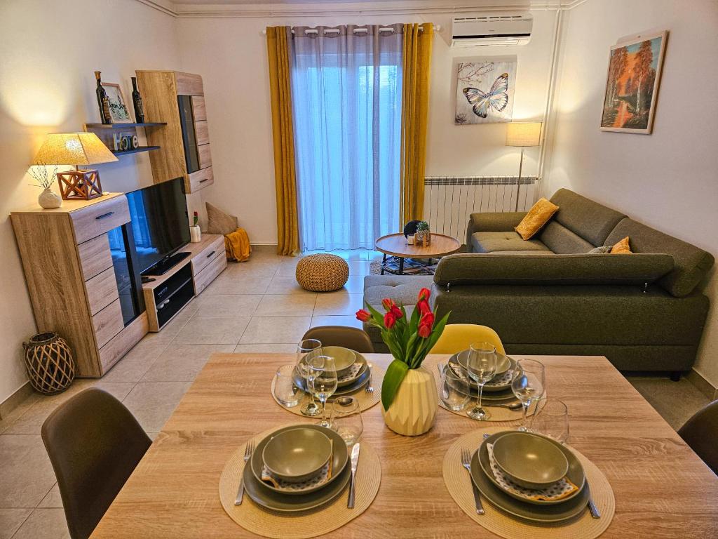 a living room with a table and a couch at Apartman Ruza 1 in Poljane