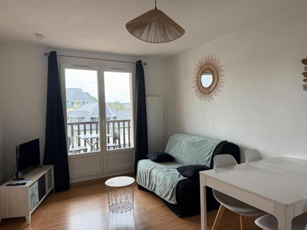 a living room with a couch and a table at T2, accès direct plage, proche thalasso in Cabourg