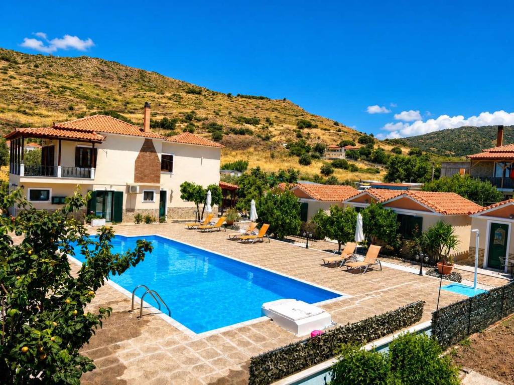 Eine Villa mit Swimmingpool vor einem Berg in der Unterkunft Apartments Fotoula in Petra