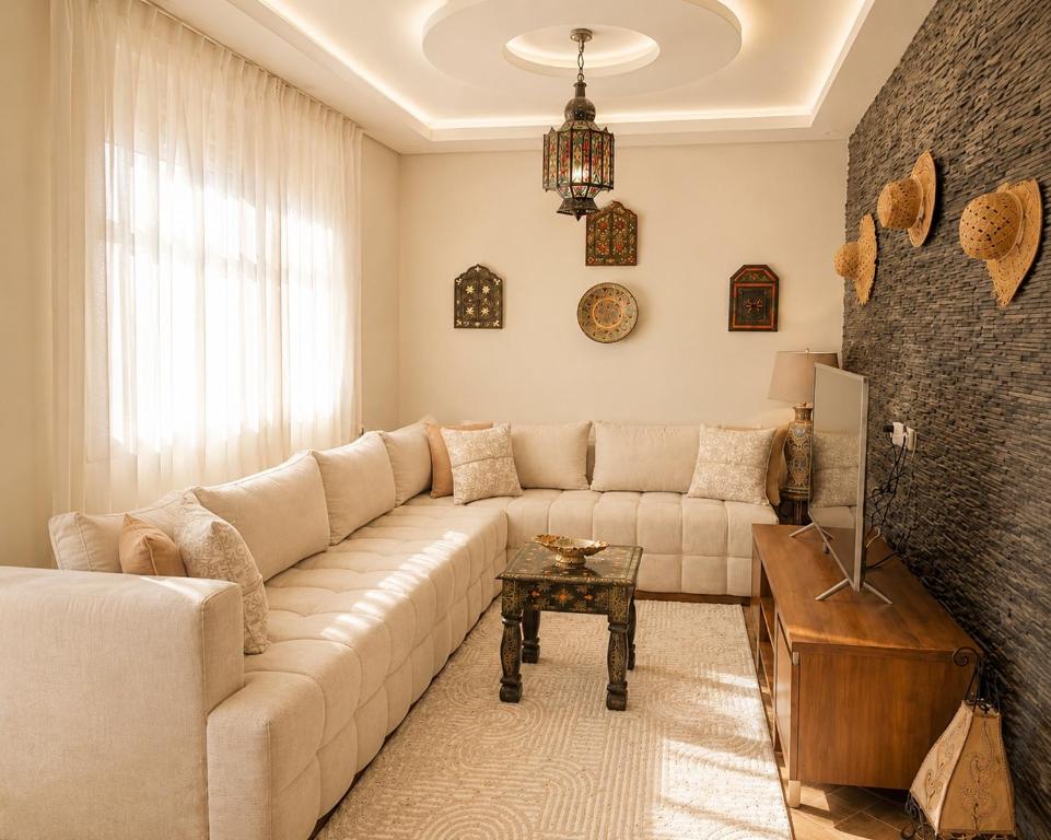 a living room with a couch and a table at Azra Luxe villa famille uniquement Family only in Saïdia