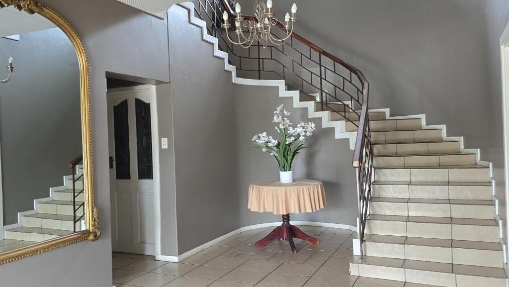 a hallway with a staircase with a vase of flowers at Crayfish Creek Guest House in Richards Bay