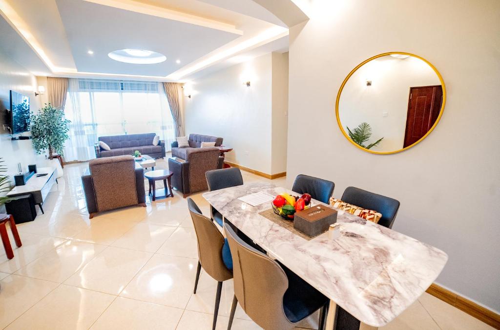 a living room with a marble table and chairs at Pecho Heights in Namulanda