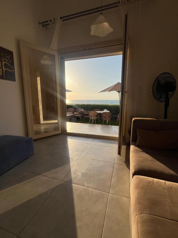 a living room with a couch and a view of the ocean at Villa Amoun,Beachfront Villa & sea view,North Coast in Sidi Kirayr