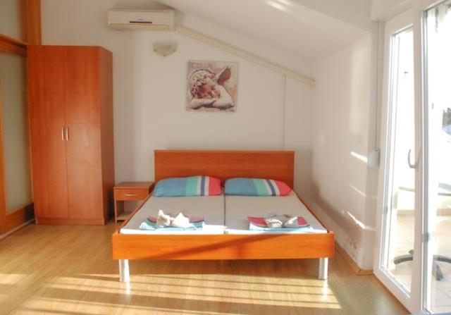 a bedroom with a bed with shoes on it at Danica Roof in Tučepi