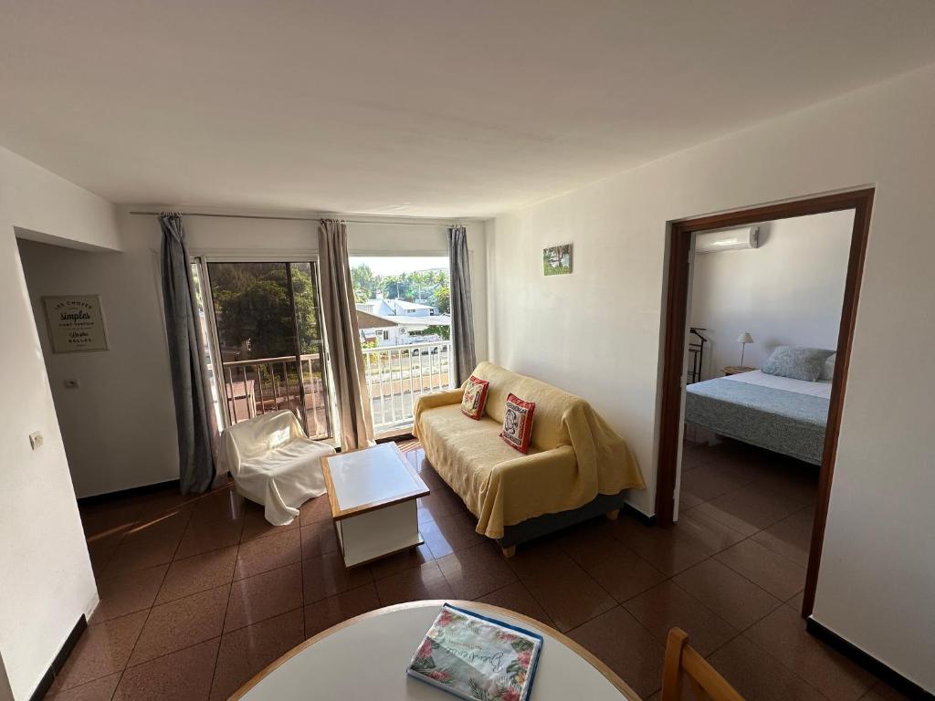 a living room with a couch and a bed at Le Tournesol in Saint-Gilles-les-Bains