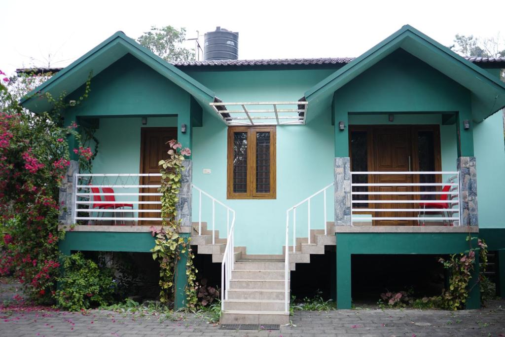 a blue house with stairs in front of it at Mistnview By SHELTERS in Meppādi