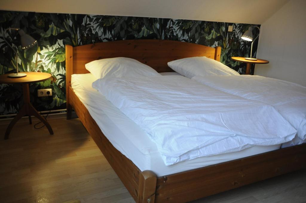 a bed with white sheets and pillows in a bedroom at Cafe-Kuckuck in Salzwedel