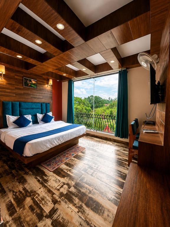 a bedroom with a bed and a large window at Hotel Royal Orbit By Arony Hospitality Dehradun in Dehradun