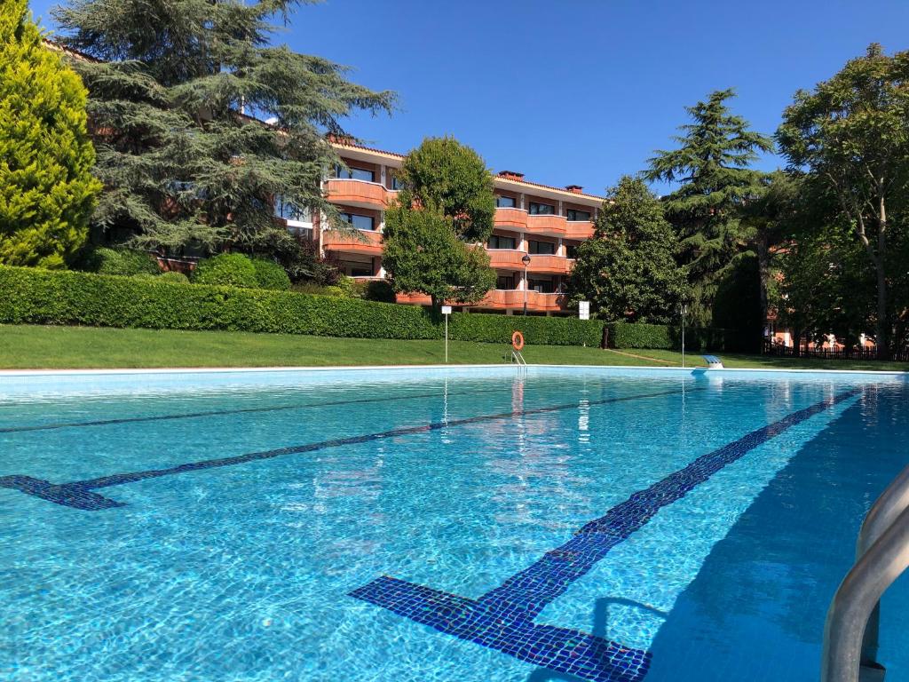 a swimming pool with blue water in front of a building at Checkin Montserrat in Collbató