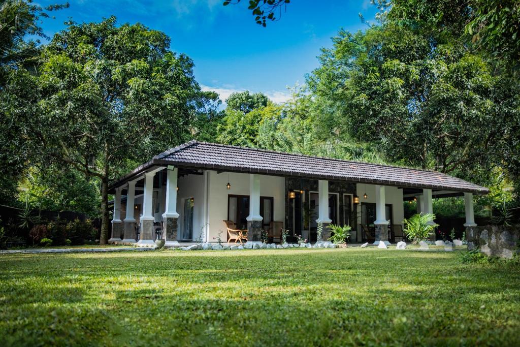 a small white house with a large yard at Villa D55 - A Private Villa with Character & Comfort in Kandy