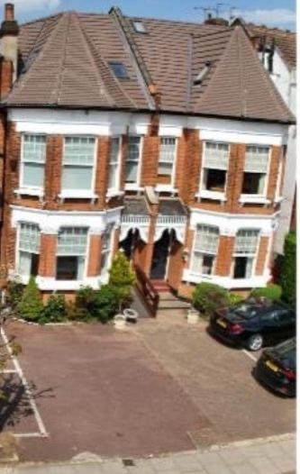 a large brick house with a car parked in front of it at Catherine Lodge Finchley in Whetstone