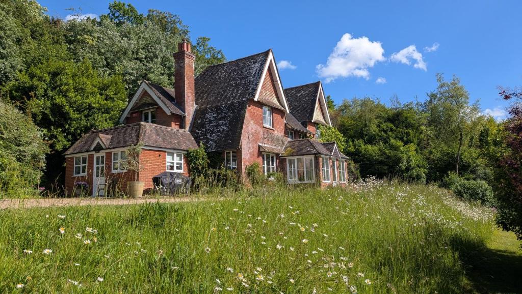 ein altes Backsteinhaus in einem Grasfeld in der Unterkunft Whitebeams in Canterbury