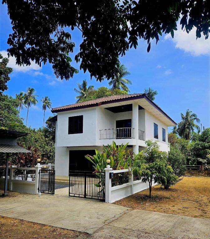 a white house with a fence in front of it at Suwaree Garden in Koh Samui