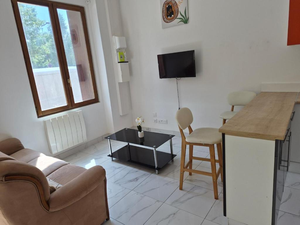 a living room with a couch and a table at Maison chaleureuse avec tous confort in Elbeuf