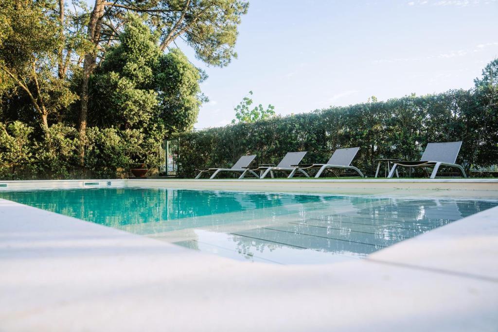a group of chairs sitting next to a swimming pool at Sun House in Cabedelo in Viana do Castelo