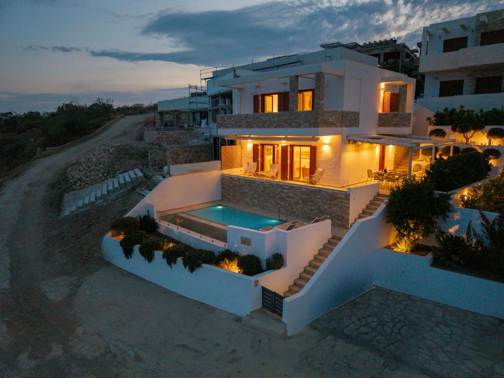 an aerial view of a house with a swimming pool at Villa Marelia - Seafront villa with infinity pool in Megas Gialos - Nites