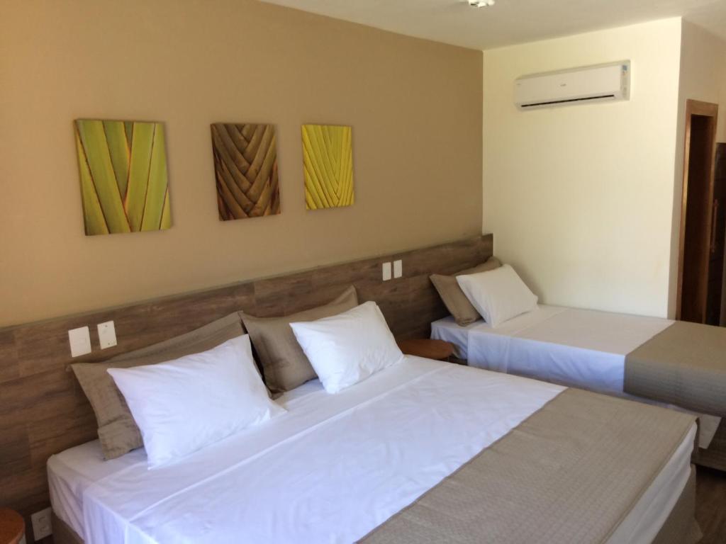 two beds in a hotel room with two beds at Ravenala Hotel in Arraial d'Ajuda