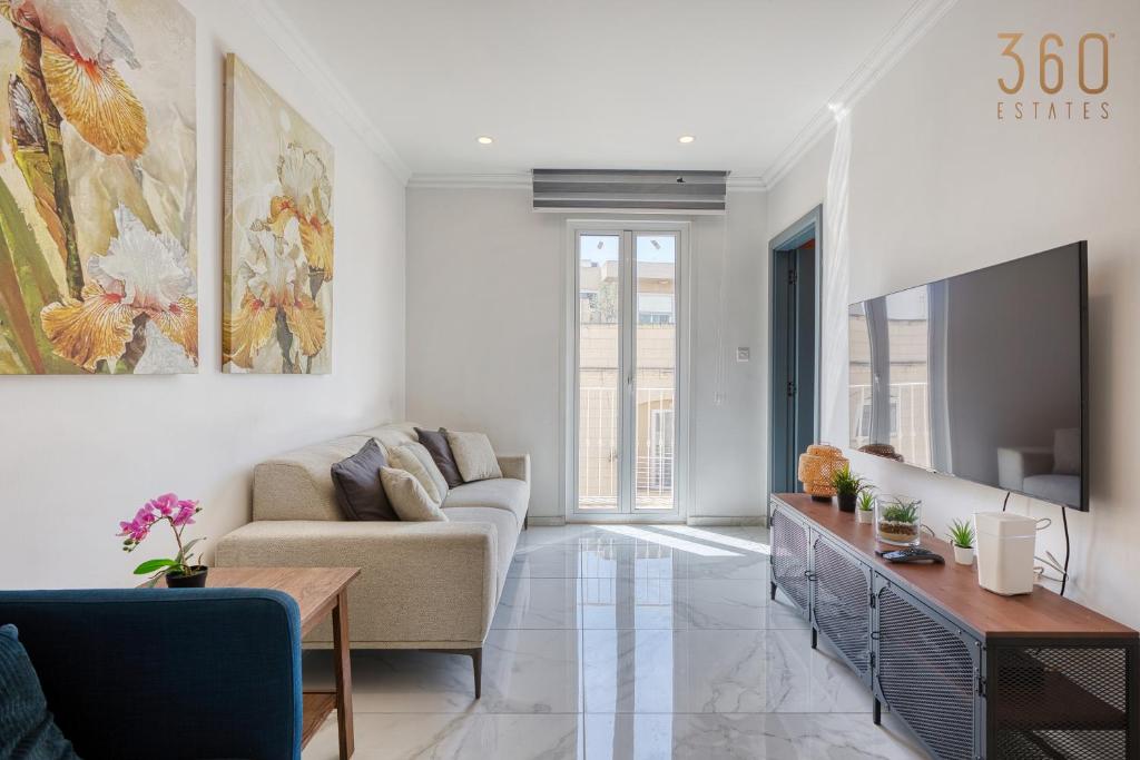 a living room with a couch and a tv at Central Malta Gem - 3BR Apartment with Balconies in Mosta
