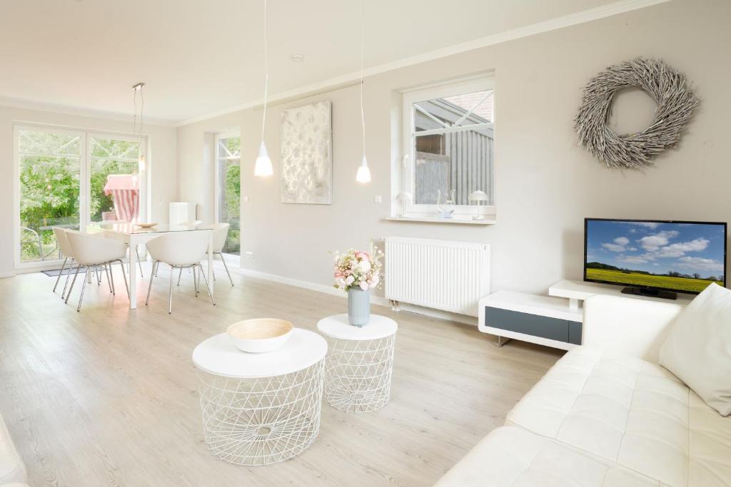 a white living room with a couch and a table at Haus Sommerzeit in Fissau