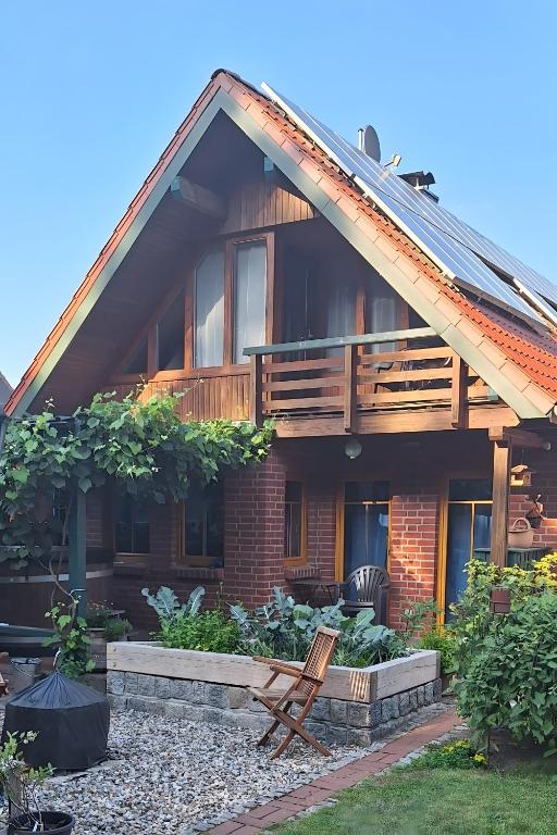 a house with a wooden roof and a yard at Ferienwohnung Am Spröckel in Bleckede