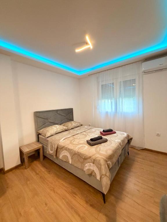 a bedroom with a bed with a blue light on it at Taca 2 - Airport apartman in Surčin