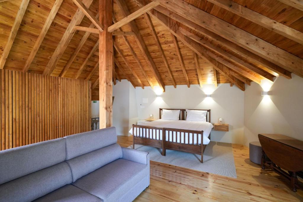 a living room with a couch and a bed at Feel Discovery Casa da Aldeia in Mós