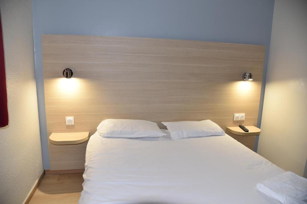 a bedroom with a large white bed with two pillows at FastHotel Thionville in Thionville