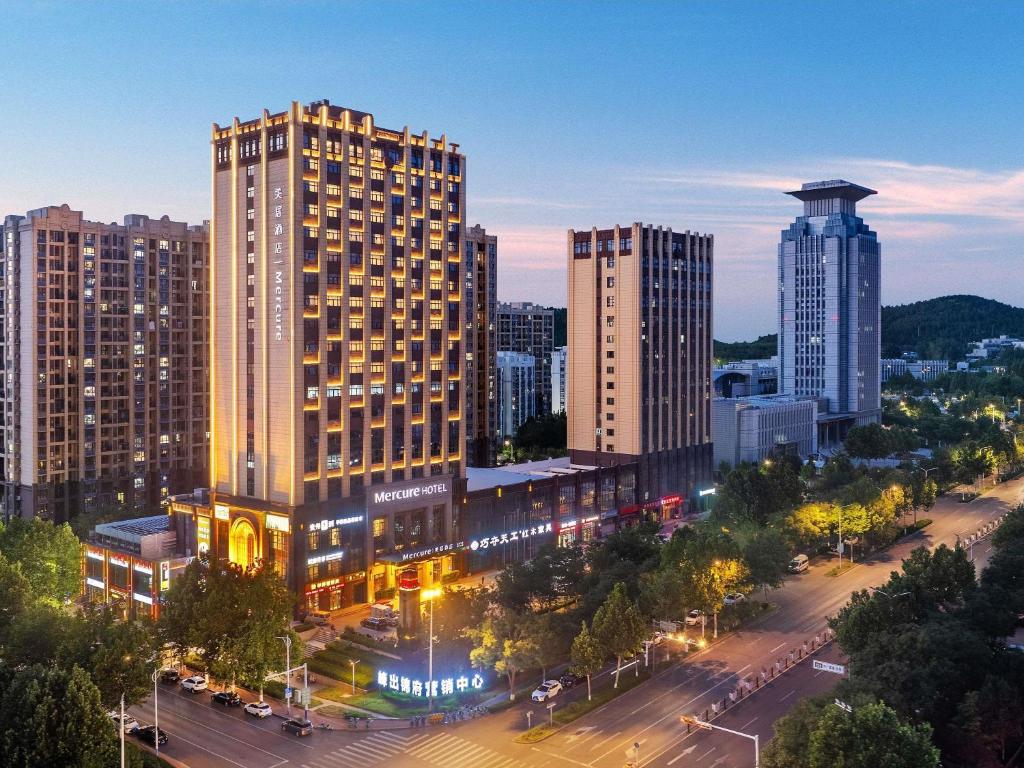 a view of a city at night with tall buildings at Mercure Jinan Pingyin in Pingyin