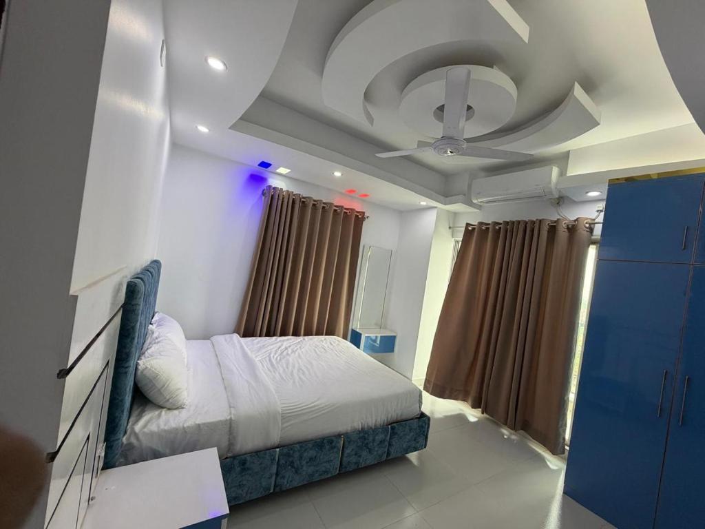 a bedroom with a bed and a ceiling fan at Hotel Moon Light in Dhaka