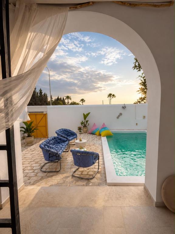 a patio with chairs and a swimming pool at Kefia house in Hammamet Nord