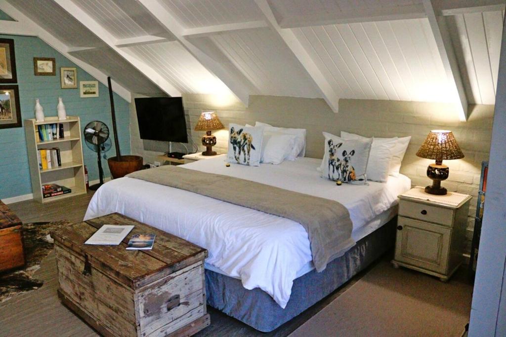 a bedroom with a large bed with white sheets and pillows at Matopos Loft in Stilbaai-Wes