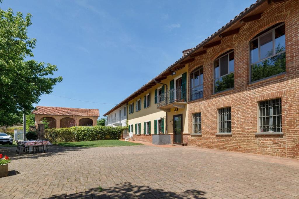 a brick building with a brick driveway in front of it at Casa Centomila Volte Benvenuti in Tigliole