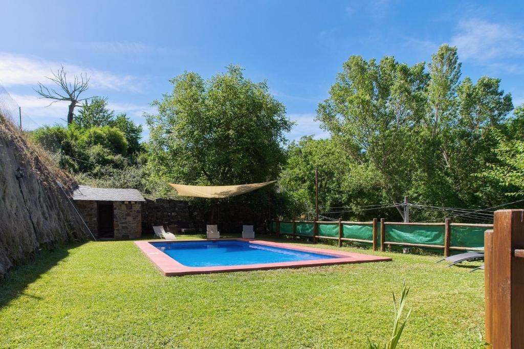 a backyard with a swimming pool in the grass at Ribera del Cantero in Ponferrada