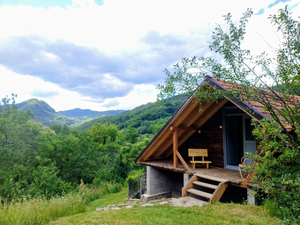 a small cabin in a field with mountains in the background at The hayloft in Grohoţele