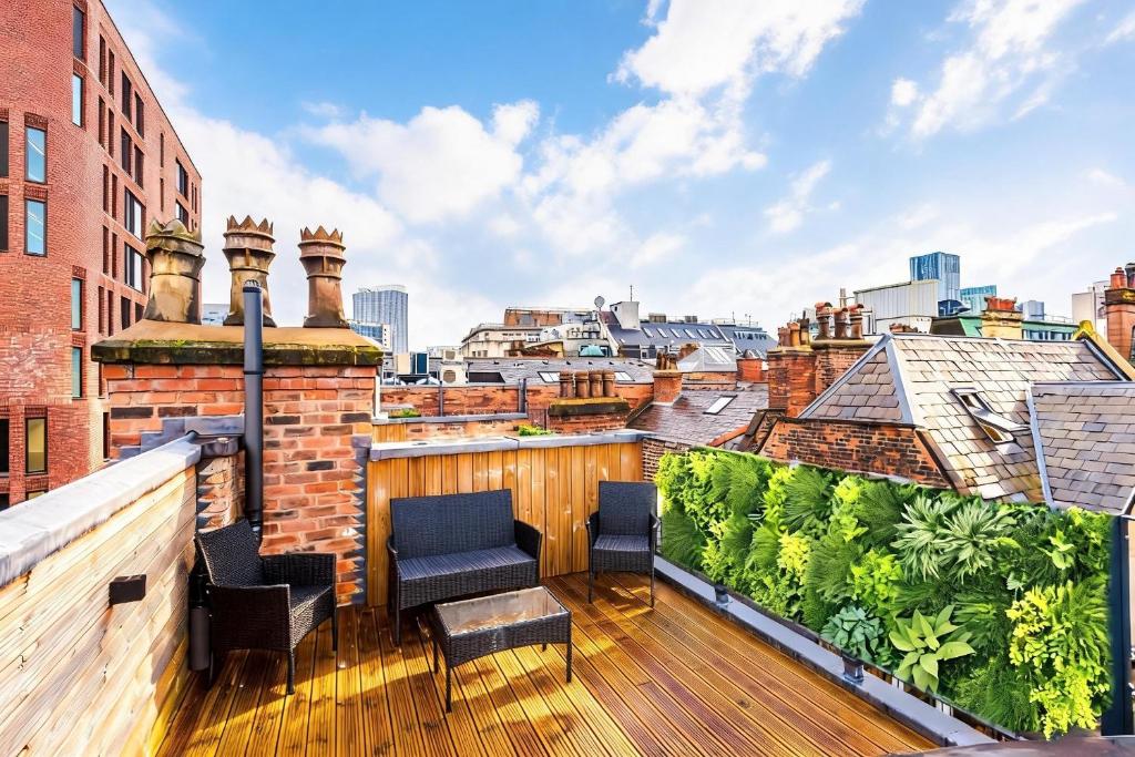a balcony with chairs and a view of the city at Stylish 3-Bed Central Stay - Roof Terrace & Parking in Manchester