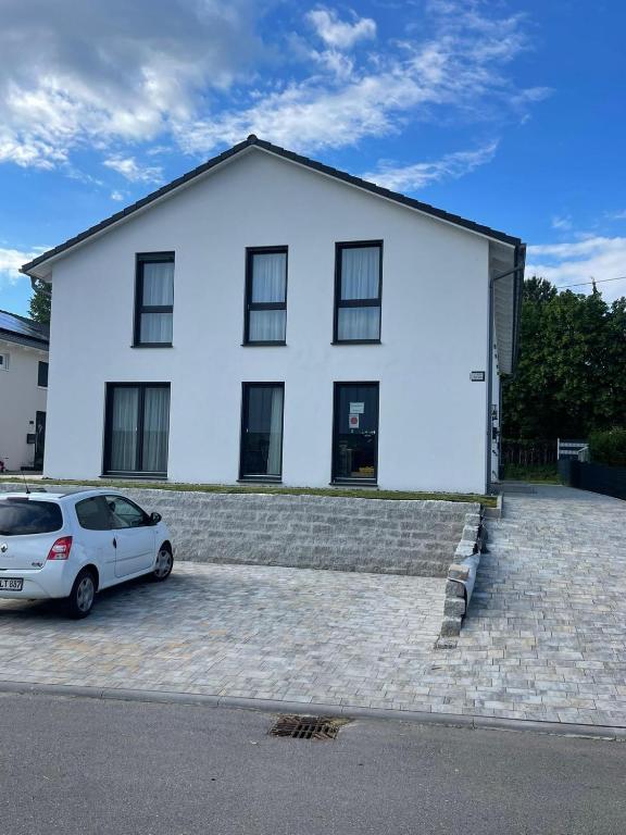 a white house with a car parked in front of it at Haus Auf Bulz - Klippeneck in Denkingen