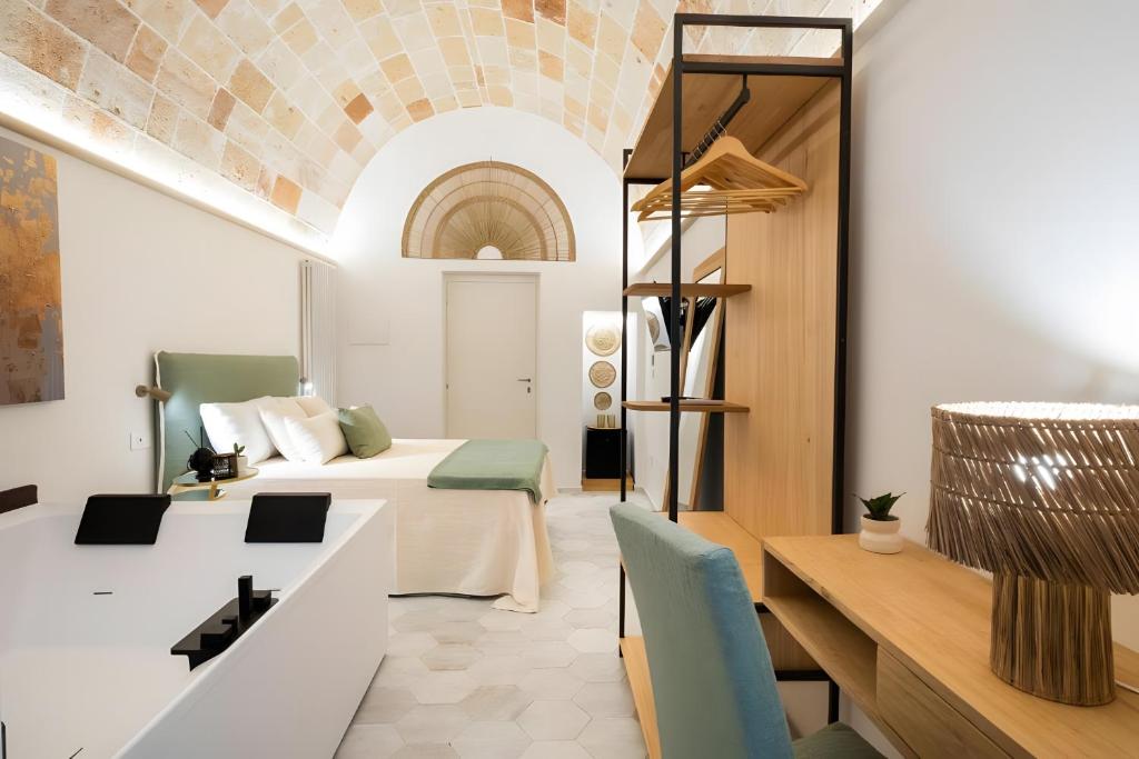 a hotel room with a bed and a desk at Celine Dimora e Suite in Copertino