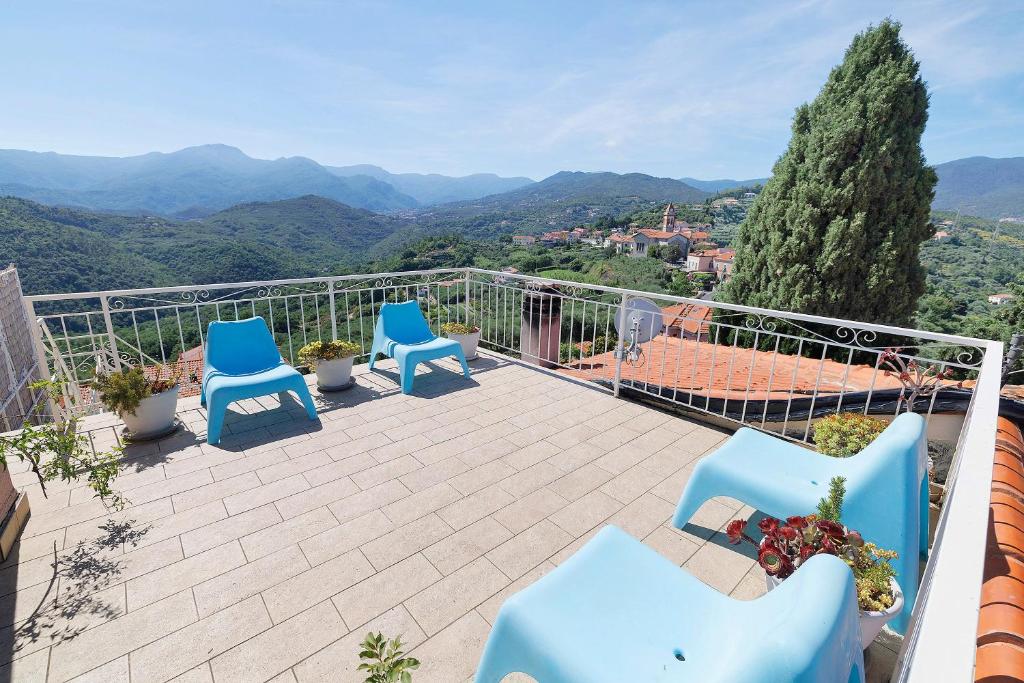 a balcony with blue chairs and a view of mountains at Rosa Di Mare Guest House in Finale Ligure