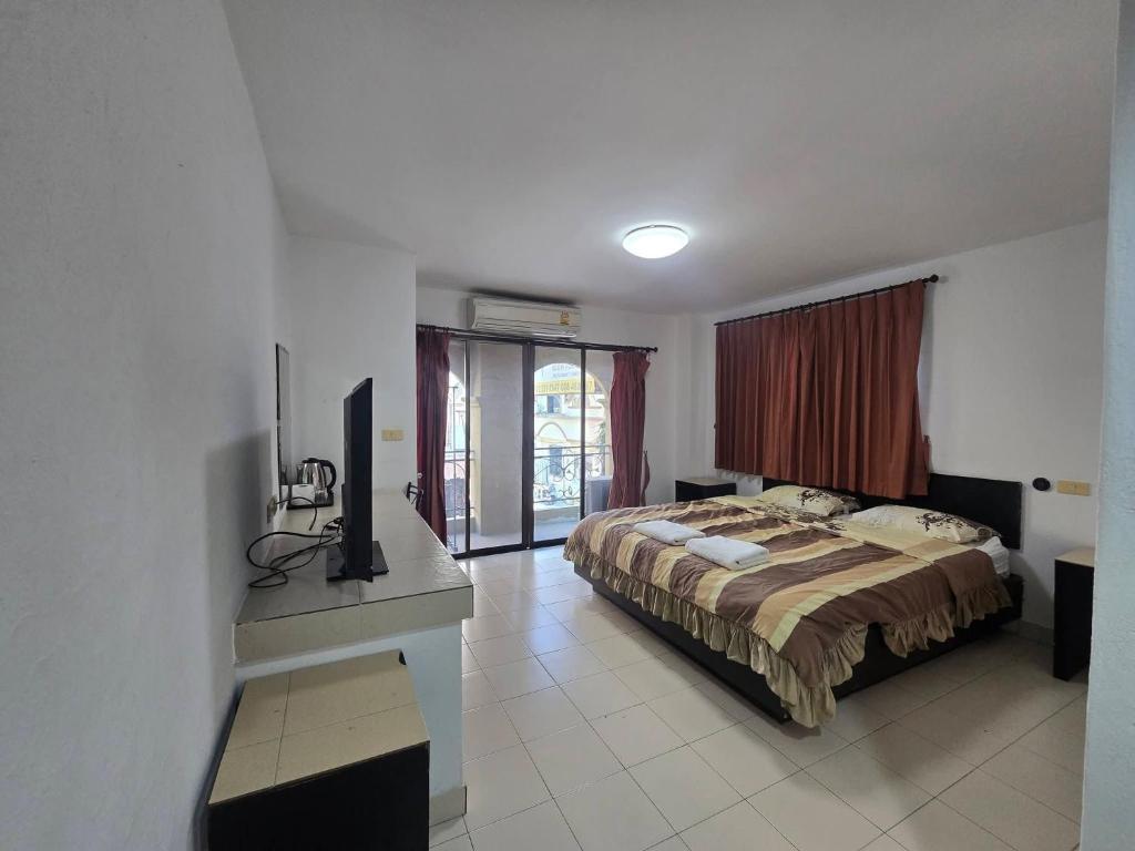 a bedroom with a bed and a television in it at The Royal Pattaya Cantina Near Walking Steer in Pattaya South