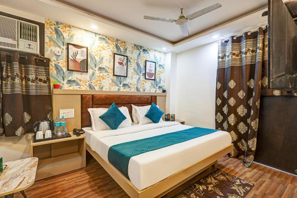a bedroom with a bed with blue pillows at Family Group with Provide By PG Hotel Near New Delhi Railway station & Karol-Bagh in New Delhi
