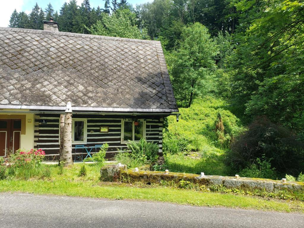 a wooden house with a roof on the side of the road at House in the rocks in Česká Metuje