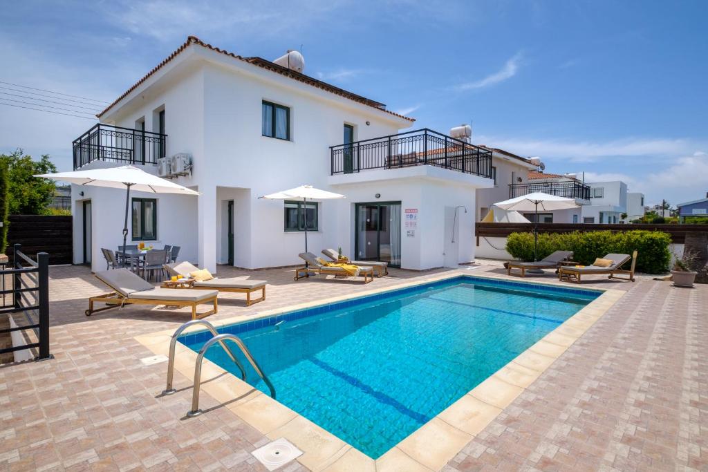 a villa with a swimming pool in front of a house at Melia Villa II by Nomads in Kissonerga
