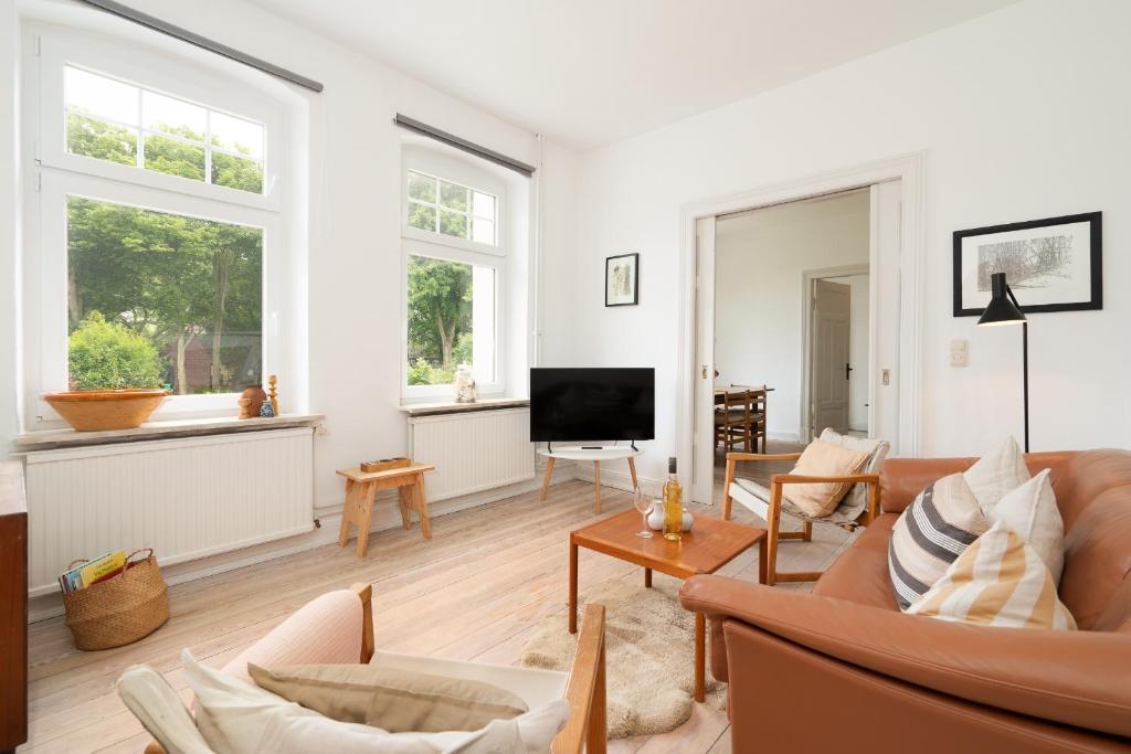 a living room with a couch and a tv at Ferienhaus Stranden Westfehmarn in Fehmarn