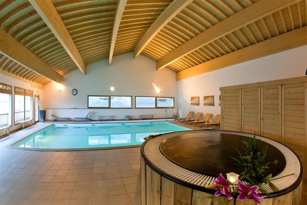 a large swimming pool in a large room at Appartement Orelle spa et piscine in Orelle