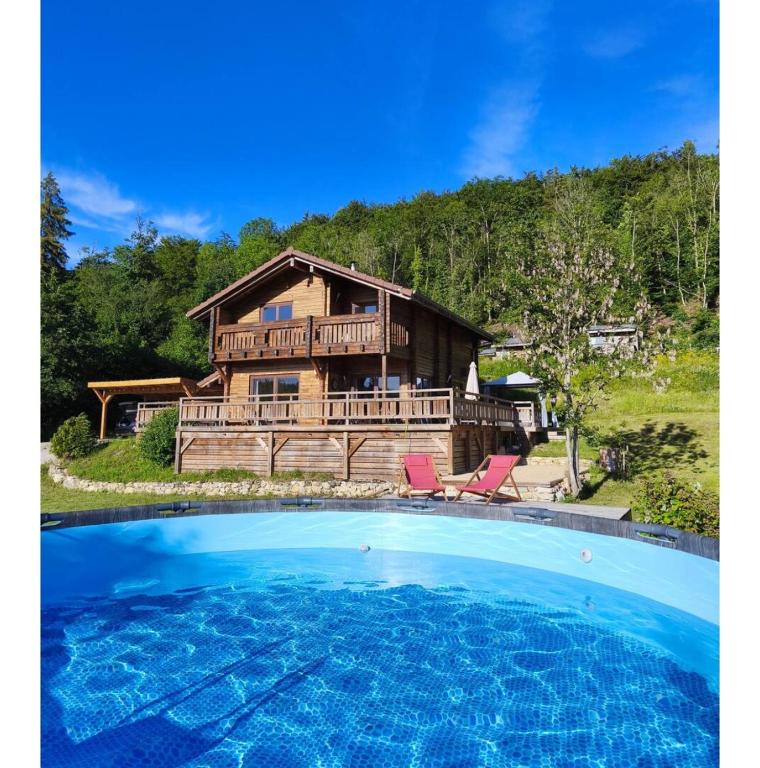 a log house with a large pool in front of it at Chalet d'exception avec jacuzzi sauna et piscine - proche station du retord in Sainte-Blaizine