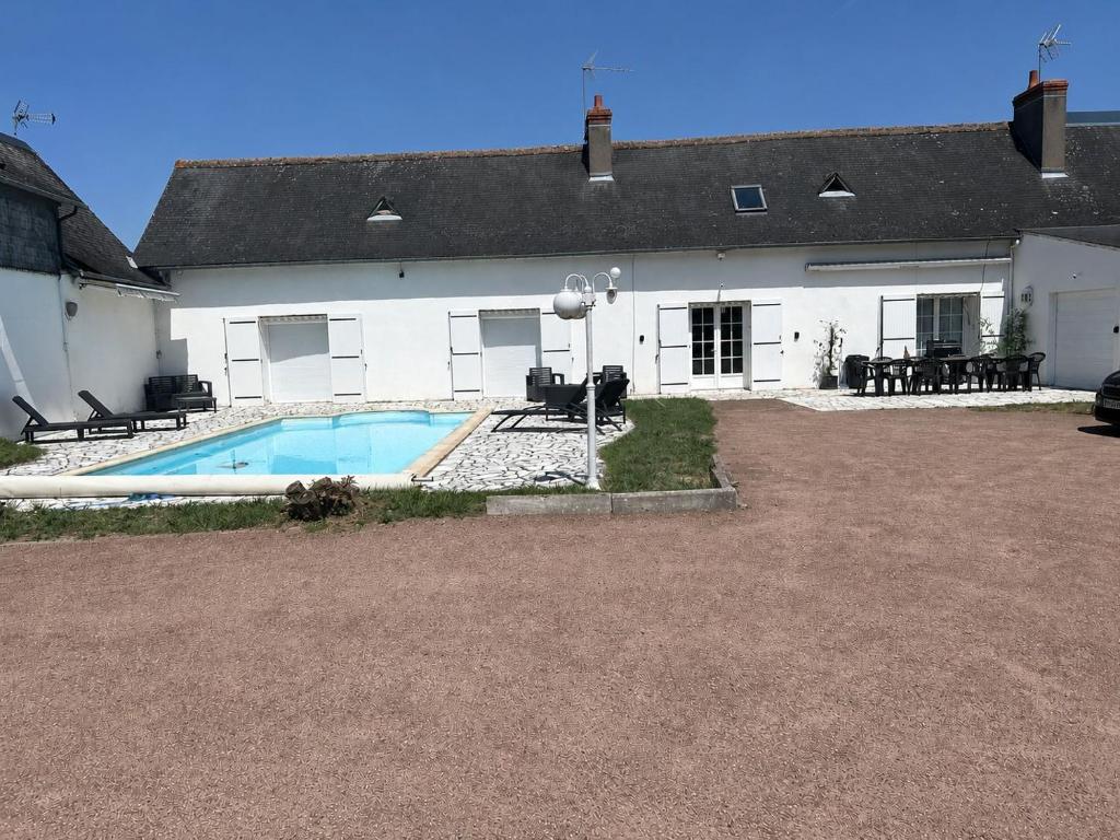a house with a swimming pool in front of it at Maison privée spacieuse avec piscine chauffée pour 8 personnes in Joué-lès-Tours