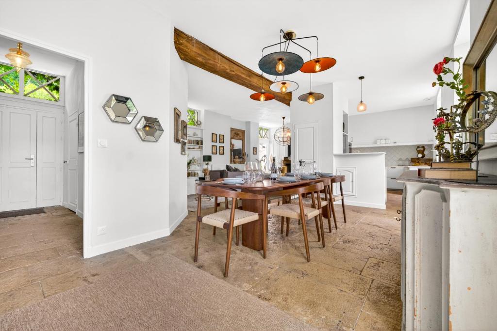 a kitchen and dining room with a wooden table and chairs at Fanny à la Campagne in Nantoux