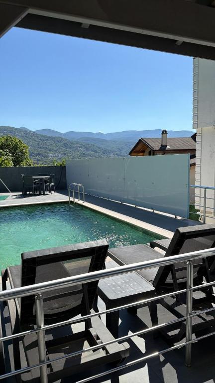 a swimming pool with two chairs and a table at WHİTE ROSE VİLLA Jakuzili ve Isıtma Havuzlu in Sapanca