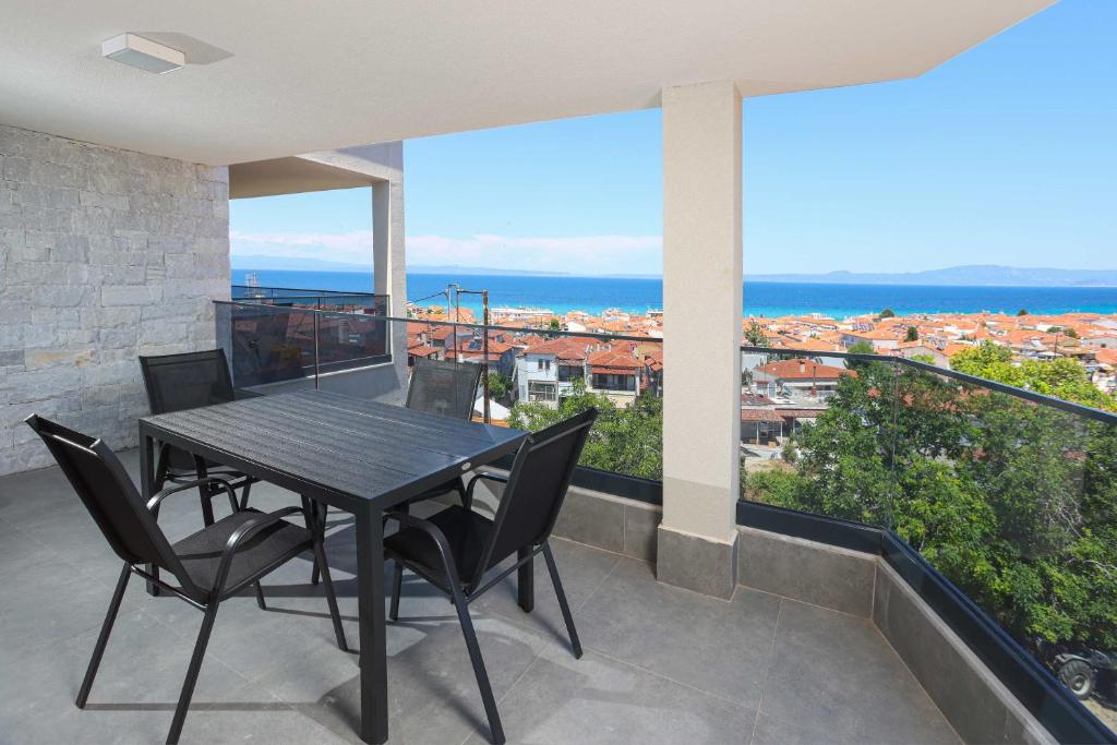 a table and chairs on a balcony with a view at Local View Apartments in Polychrono