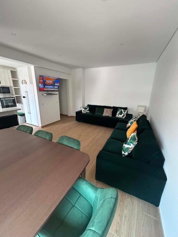 a living room with a green couch and a table at Casa Rosarinho in Faro